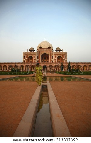 NEW DELHI, INDIA, MAY 18: Indian young woman taking a walk at the Humayun tomb with a clear blue sky. India 2009