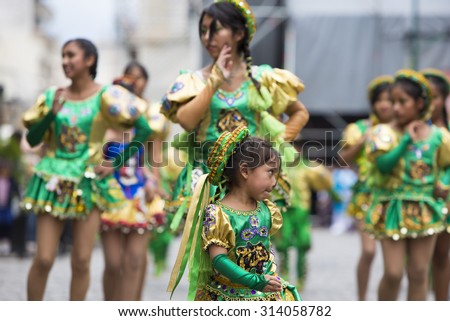 SALTA, ARGENTINA, DEC 18: Young women performers dancing and celebrating the opening of the carnival of Salta in the street with colorful costumes. North of Argentina 2014