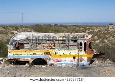SAN JUAN, ARGENTINA, DEC 4: Detail of rusted old colored school bus with broken windows and clear blue sky abandoned in the countryside in the North of Argentina 2014