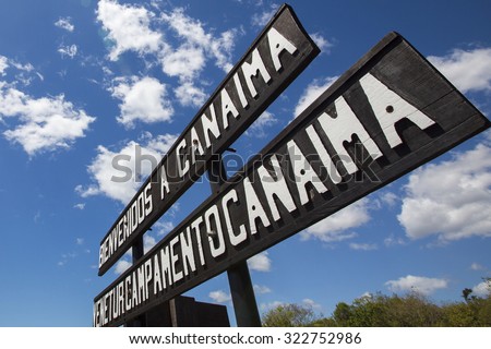 CANAIMA, VENEZUELA, APRIL 12: Information wood sign at the entrance of Canaima National Park against a blue sky, Venezuela, South America 2015