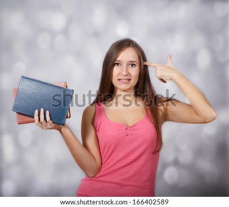 Girl holds her hand like a gun at light background