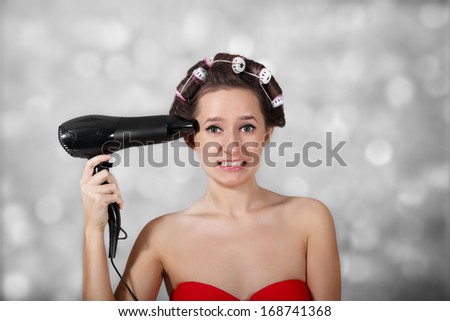 Girl holding a hair dryer as a gun