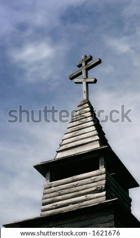 Tower of Russian wooden chapel in front of sunny sky