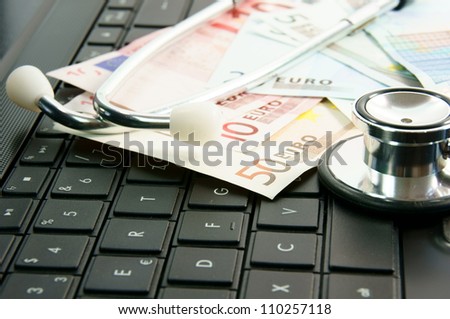 Computer with stethoscope and money