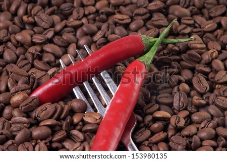 Chili peppers on a fork with coffee beans / chili and coffee