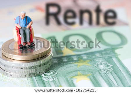 old man in a wheelchair with money and the german word pension / wheelchair user