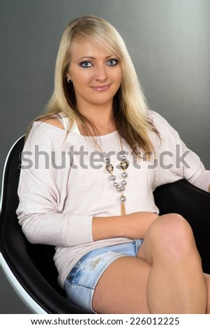 blonde woman sitting on a chair / Woman