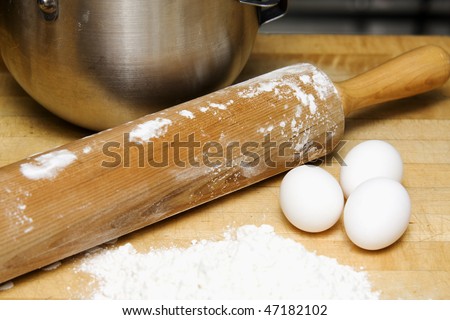 Rolling pin with flour, eggs and bowl to make cookies.