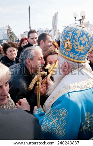 STRUGA, MACEDONIA - JANUARY 19, 2012: Orthodox believers kiss a cross during the Epiphany (Vodici, Bogojavlenje, commemoration of Saint John the Baptist) in Struga, Macedonia