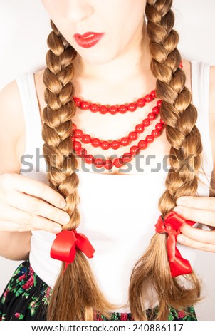 A young woman with long blonde hair tresses wearing a traditional Polish folk costume