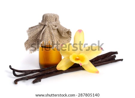 Vanilla essential oil in pharmaceutical bottle with pods and one yellow orchid. Isolated.