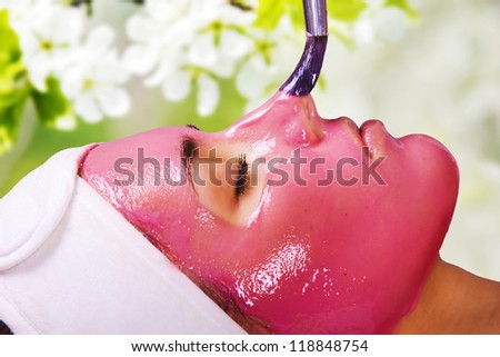 Young beautiful woman with moistening fruit facial mask at beauty salon