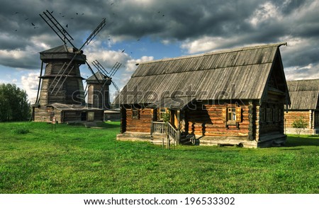 Old wooden windmill and wooden house from bars in Suzdal town, Russia. Golden Ring of Russia.