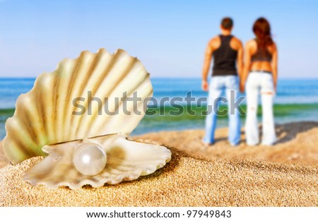 shell with pearl, couple on the beach