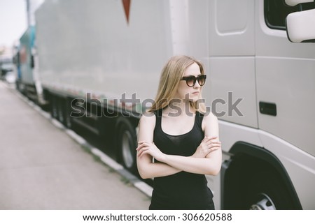 portrait of young woman with sunglasses near white cargo truck