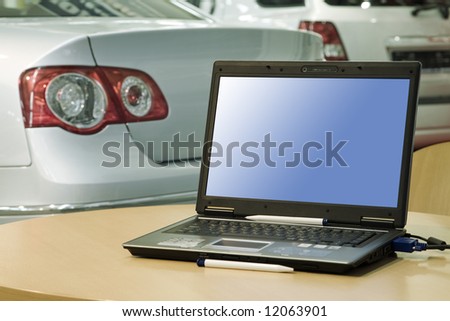 automobile sales center (laptop with empty screen for your design or ads)