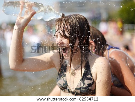 SAMARA,RUSSIA-JULY 24: young people shooting and throwing water at each other during Water Wars flash-mob, wet girl with plastic bottle,July 24, 2011, Samara, Russia