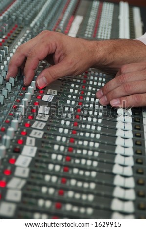 sound technician\'s hand on audio mixer