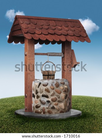 Wishing well on grassy hill with blue sky