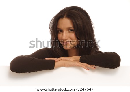 Beautiful young woman behind a white wall resting her arms on the edge looking at the camera