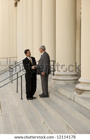 Two men shaking hands on courthouse steps
