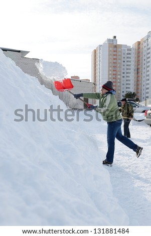 Man shoveling snow on a sidewalk after a snow storm