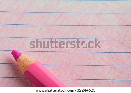 Pink color pencil with coloring on a piece of writing paper