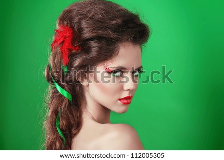 Young beautiful woman with make up and long curly hairs - isolated on green