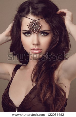 Beautiful woman with long brown hair. Fashion art photo. Beauty and Jewelry