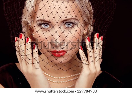 Retro Style. Vintage photo. Beautiful woman with bright makeup and red nails.
