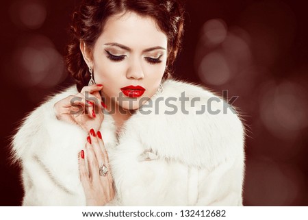 Fashion woman with red lips and nails in fur coat. Luxury and  Jewelry