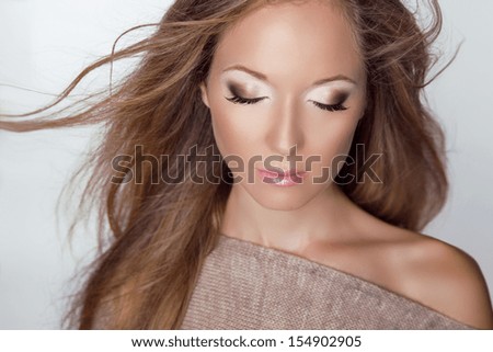 Beautiful Blond Woman. Long brown hair. Fashion model posing at studio. Health care. Eyeshadow close-up. Freshness