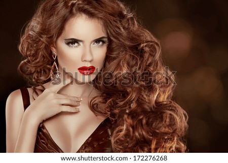 Long Curly Red Hair. Beautiful Fashion Woman Portrait. Beauty Model Girl with luxurious glossy hair, make up and accessories. Hairstyle. Wavy Hair Extensions.