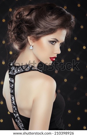Elegant brunette woman lady with makeup and hairstyle. Fashion girl model over bokeh lights background