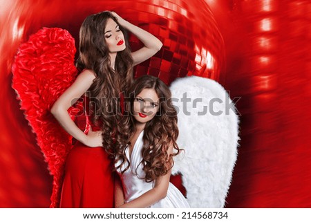 Beautiful attractive ladies with angel wings over disco ball red lights party night