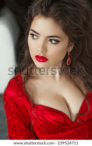 Brunette gorgeous young woman with red lips wearing in red dress. Closeup portrait of girl model.