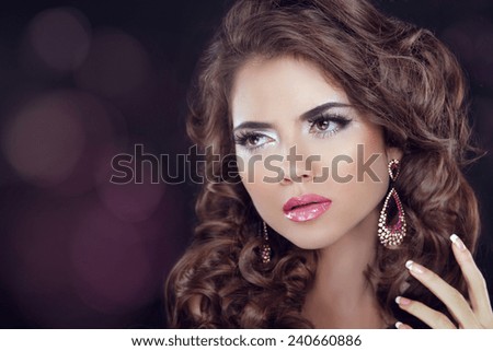Beautiful fashion girl model with wavy long hair and fashion earrings. Elegant young woman.
