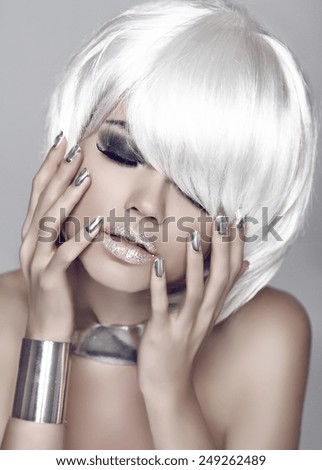 Fashion girl. Blond bob hairstyle. Eye makeup closeup. Beautiful model woman posing with manicured nails over gray background.