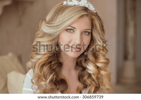 Beauty portrait of attractive smiling girl bride with long curly hair style and makeup at wedding day. Bridal morning concept.
