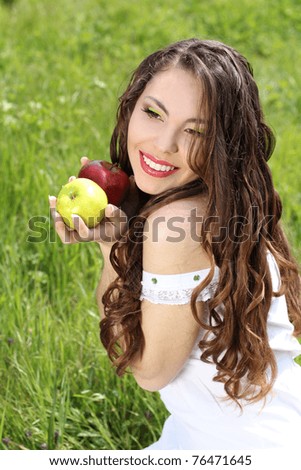 Happy smiling young woman present apples on the nature