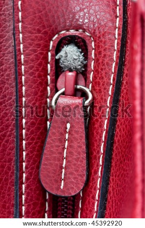 close up detail of the zipper on red leather bag