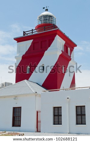 Green point\'s brightly colored red and white painted light house, during a bright sunny day in Cape Town, South Africa
