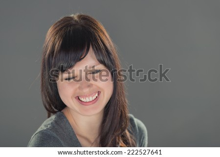 Isolated portrait head shot of young, beautiful white business women, smiling with brunette hair on white studio background. She shows a clean, corporate style with fresh, natural skin and makeup.
