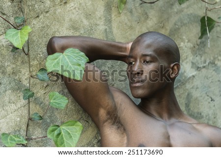 Sad black, african american man, thinking against a concrete wall, wearing no shirt