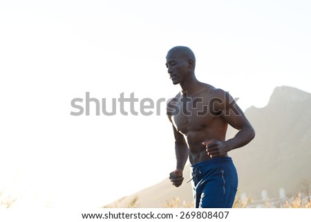 Athletic man running along road