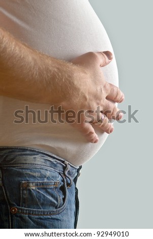 Overweight mid-adult man with hand on belly, mid section