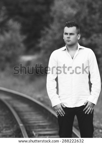a young man on a railway line black and white photography
