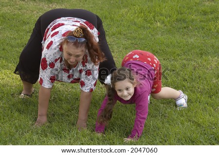smiling grandmother and young granddaughter on a grass