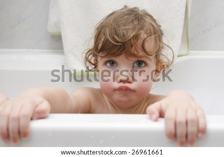 Little girl is taking a bath and pouting her lips.