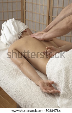 Woman is getting back massage from a physiotherapist.